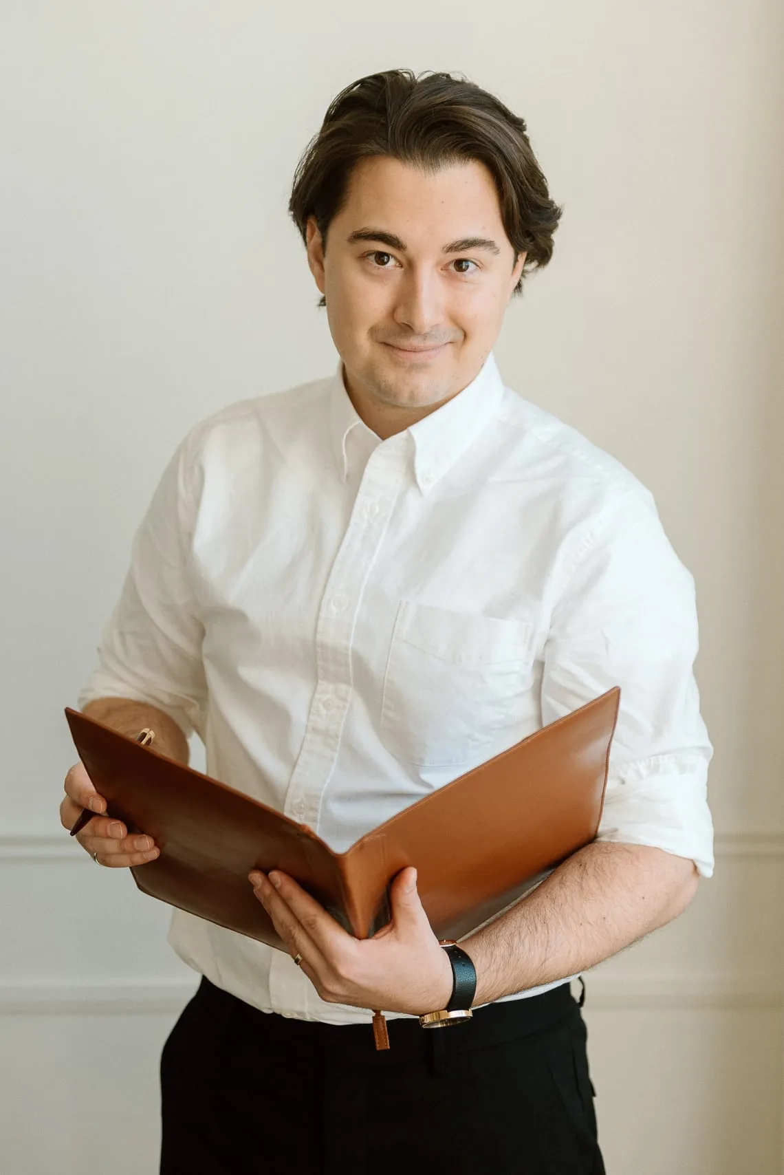 Vitalijs Arkulinskis holding a leather folio